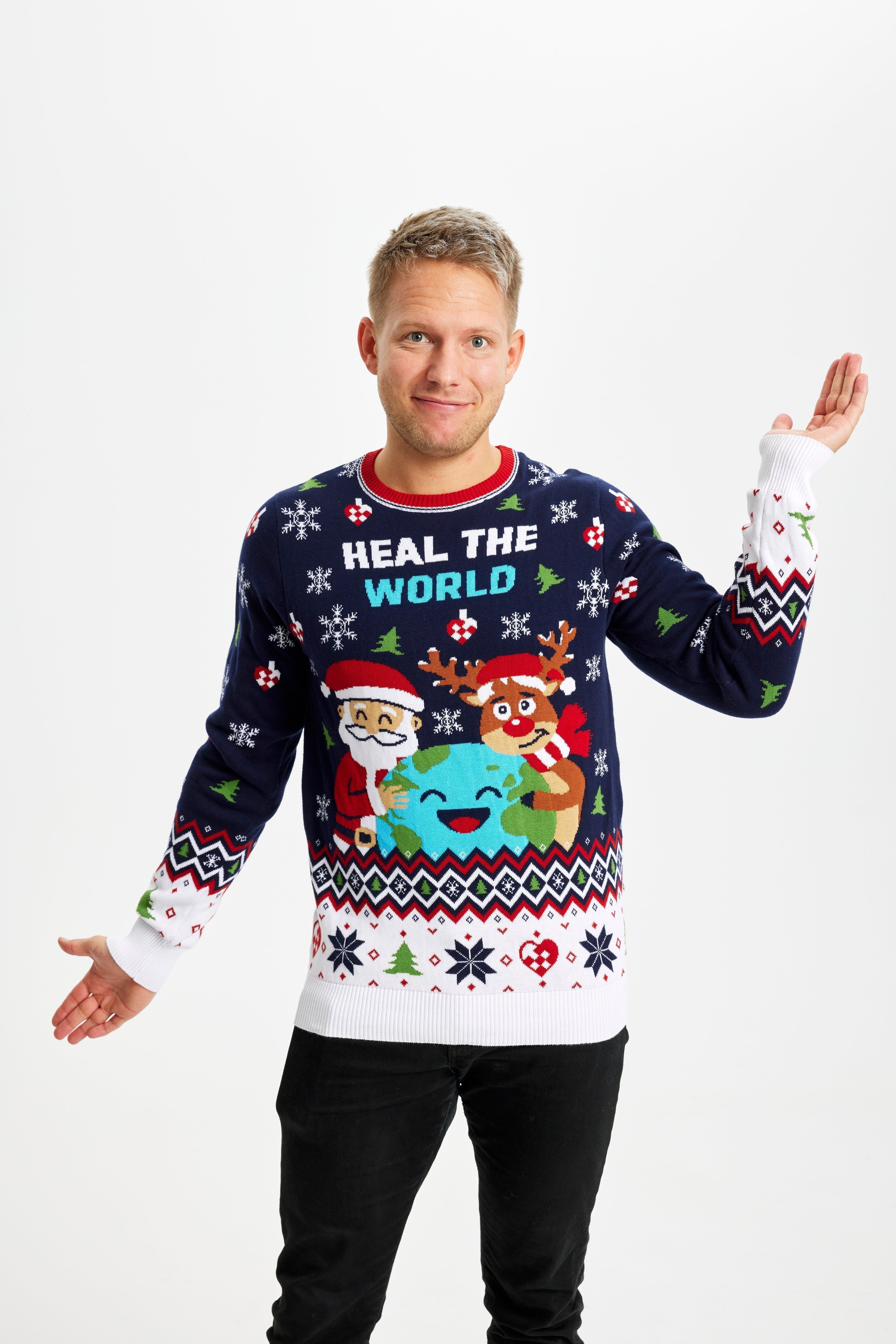 Un homme pose vêtu d'un pull de Noël bleu et blanc portant l'inscription